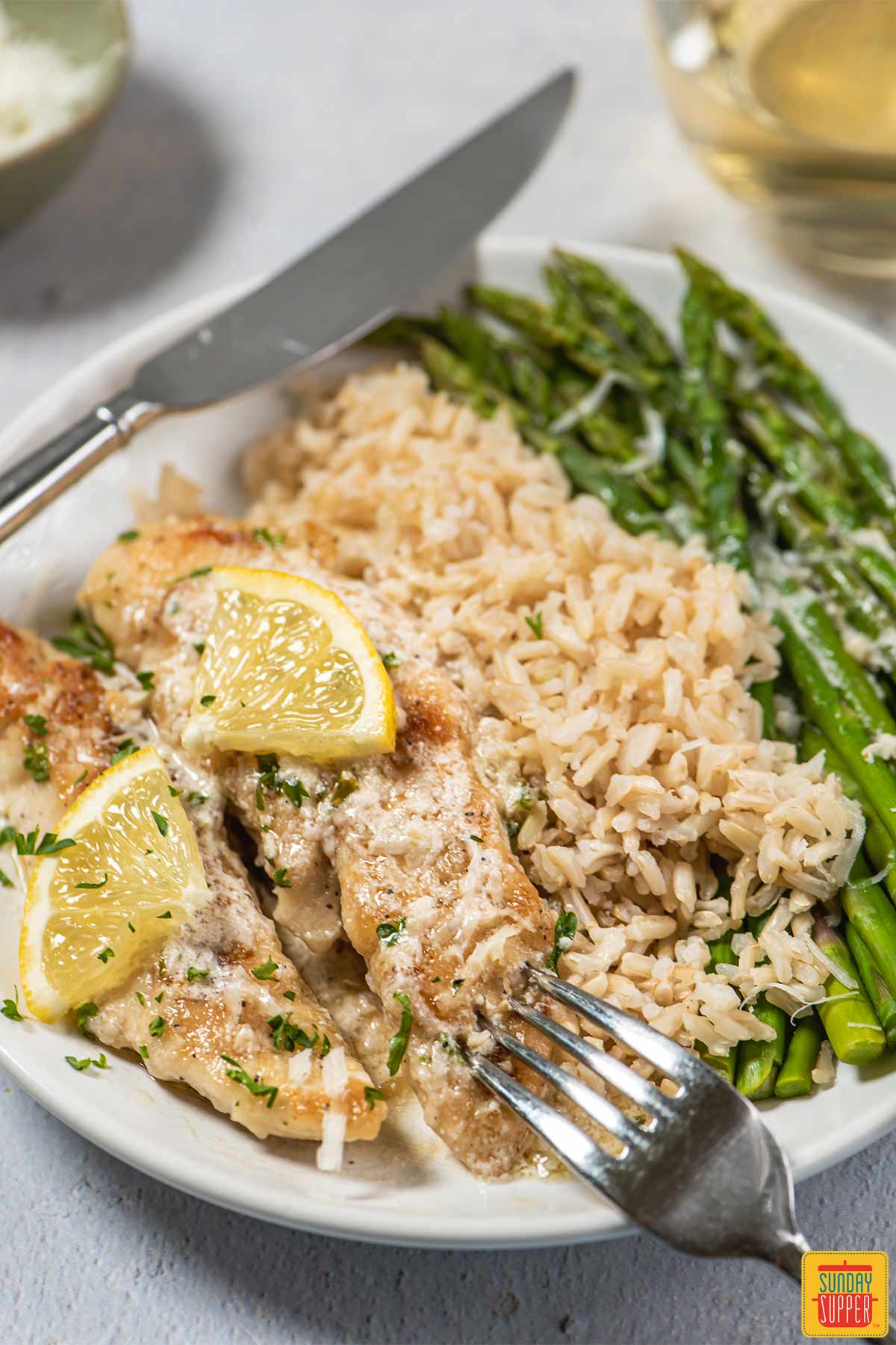 lemon butter chicken tenders on plate with vegetables and rice