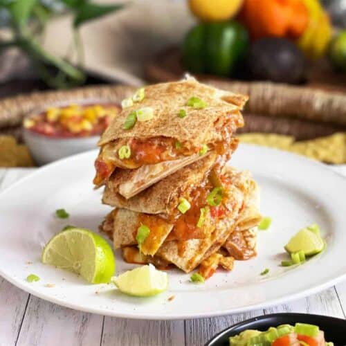 baked quesadillas stacked on a white plate