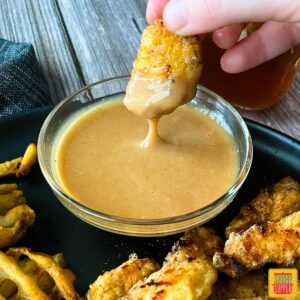 Dipping a chick-fil-a nugget in homemade chick-fil-a sauce