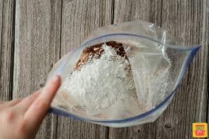 Mixing flour and seasoning in a plastic bag