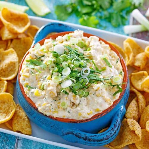 Street corn dip in a blue bowl with corn chips