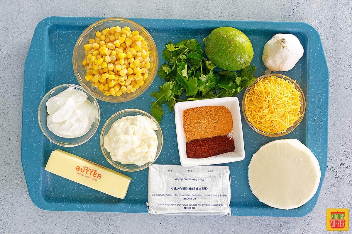 Elote dip ingredients on a blue tray