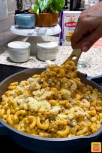 Mixing Parmesan cheese into pink pasta