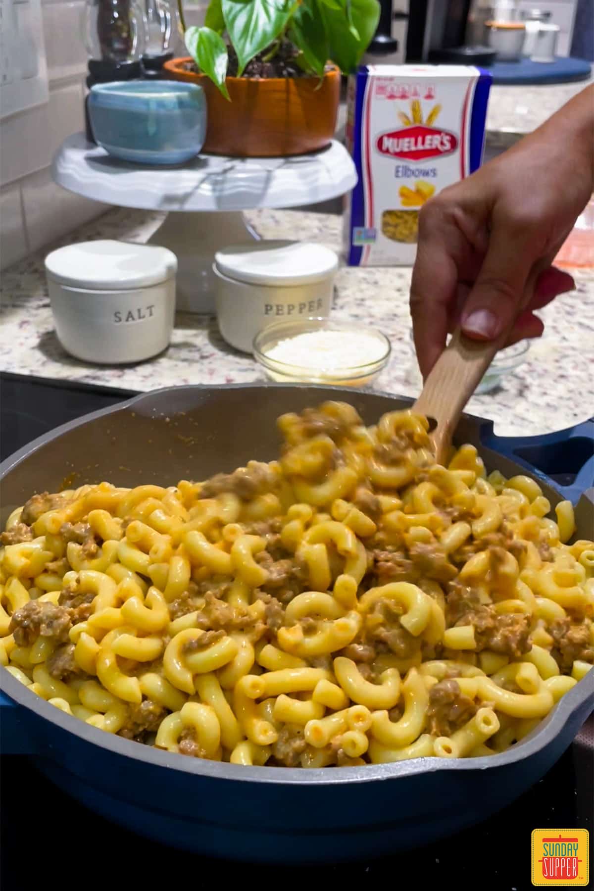 Mixing pasta into sausage and sauce