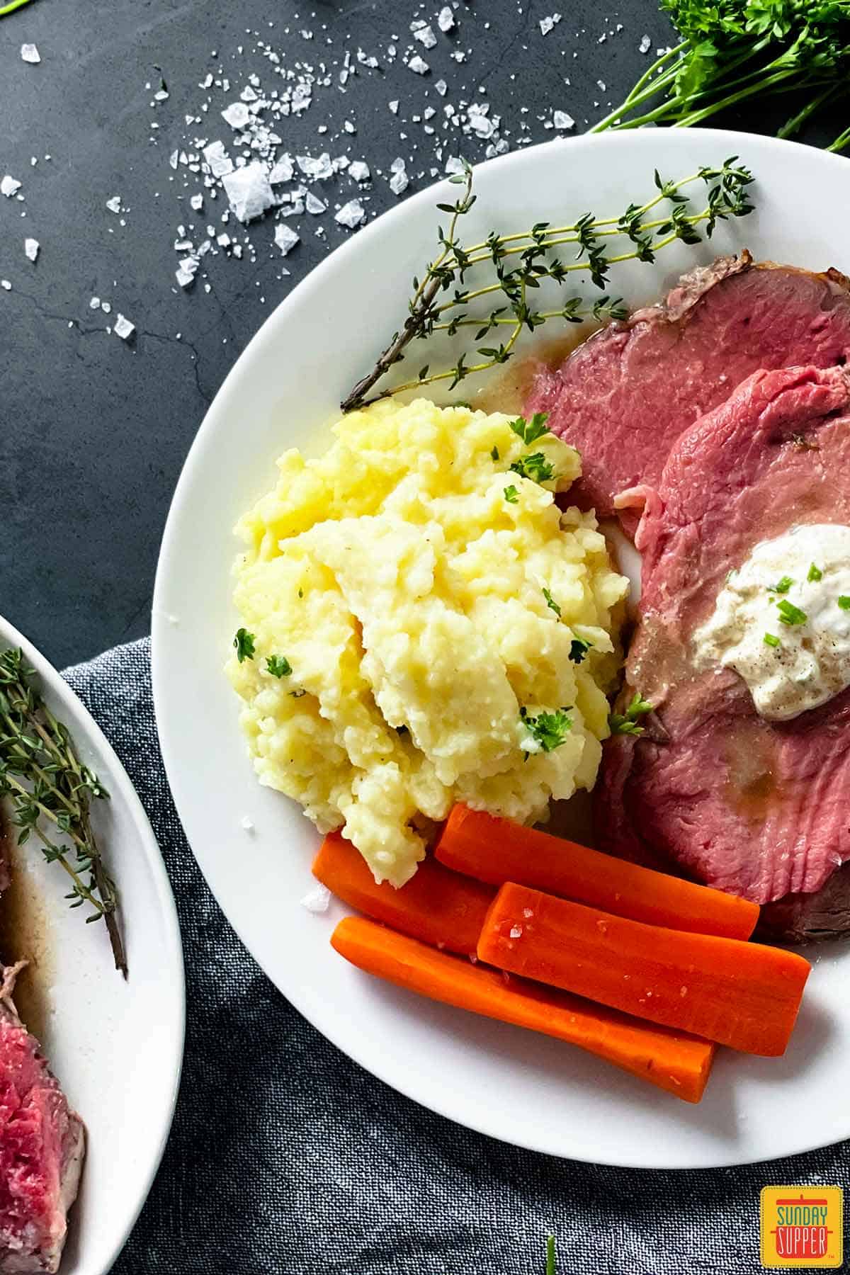 creamy mashed potatoes on a plate with prime rib