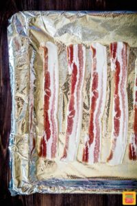 uncooked bacon on a foil sheet