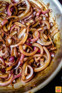 caramelized onions for loaded burgers in a skillet