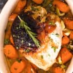 Roast turkey breast in a pan with carrots and herbs
