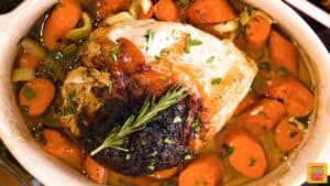 Roasted turkey breast in pan with carrots and herbs