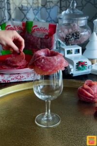 Folding salame over the rim of a glass