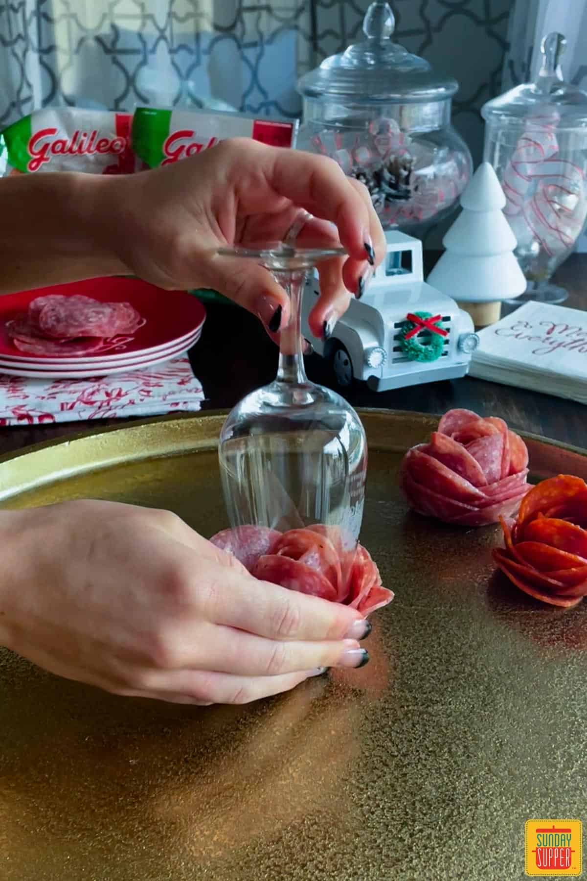 Flipping salami rose onto a platter out of glass