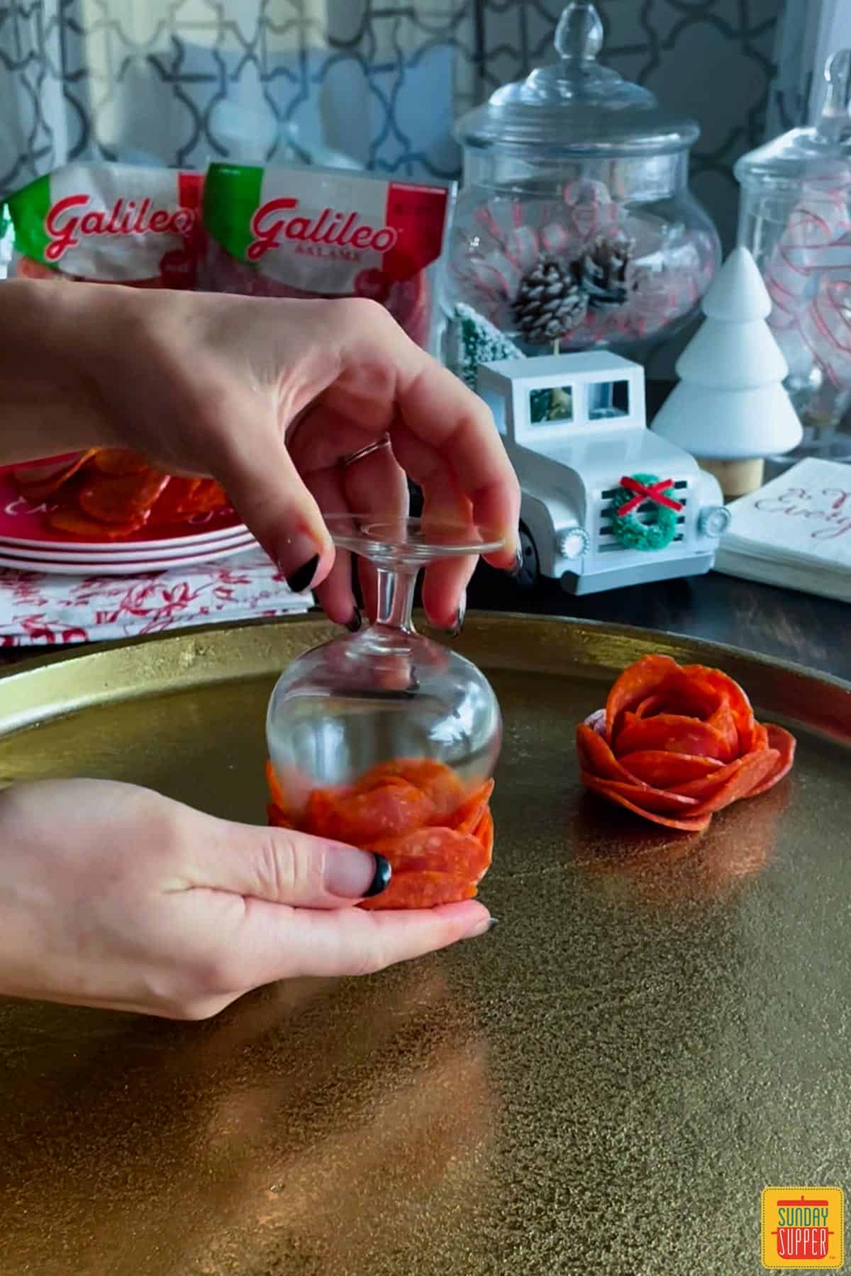 Taking pepperoni rose out of glass onto platter