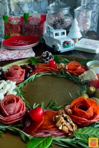 Charcuterie board decorated with rosemary and pinecones