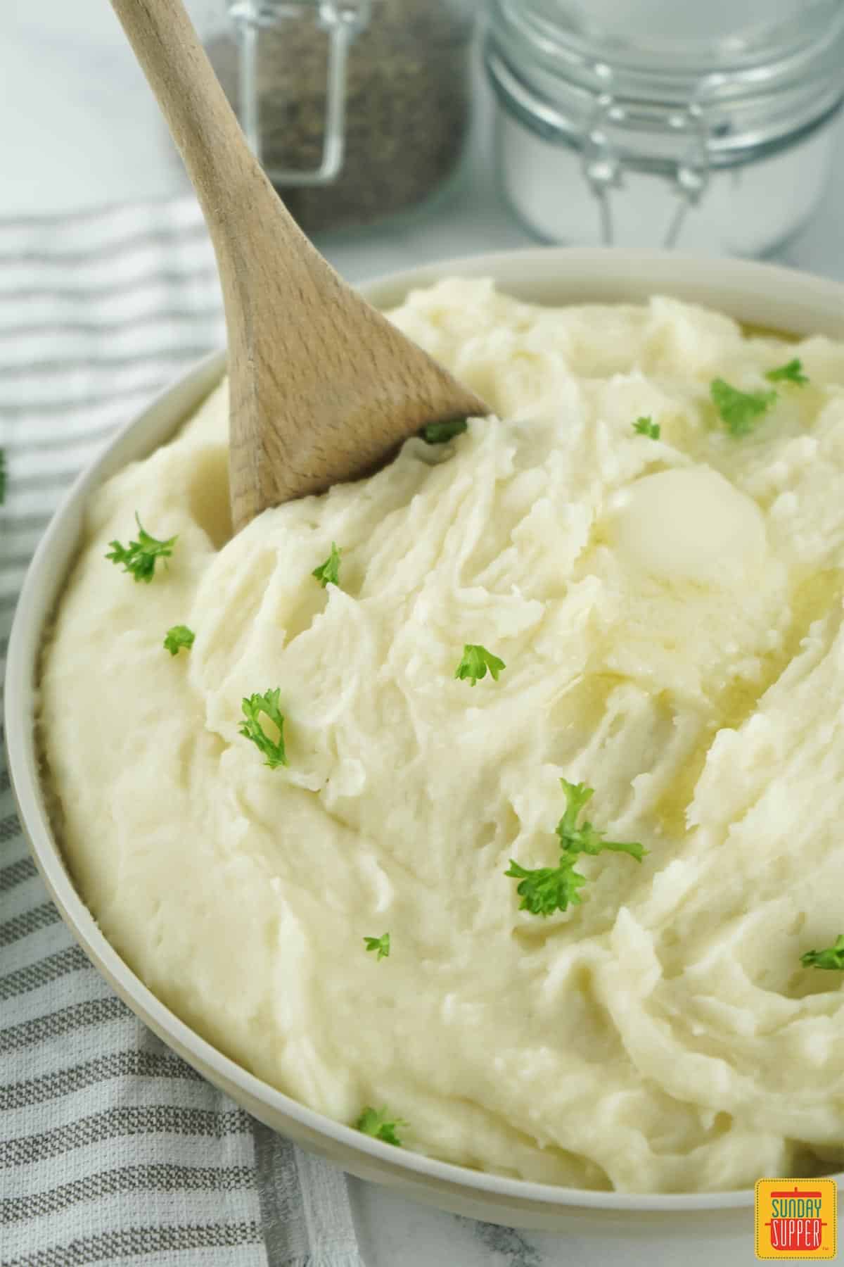 Instant pot mashed potatoes with wooden spoon in a bowl