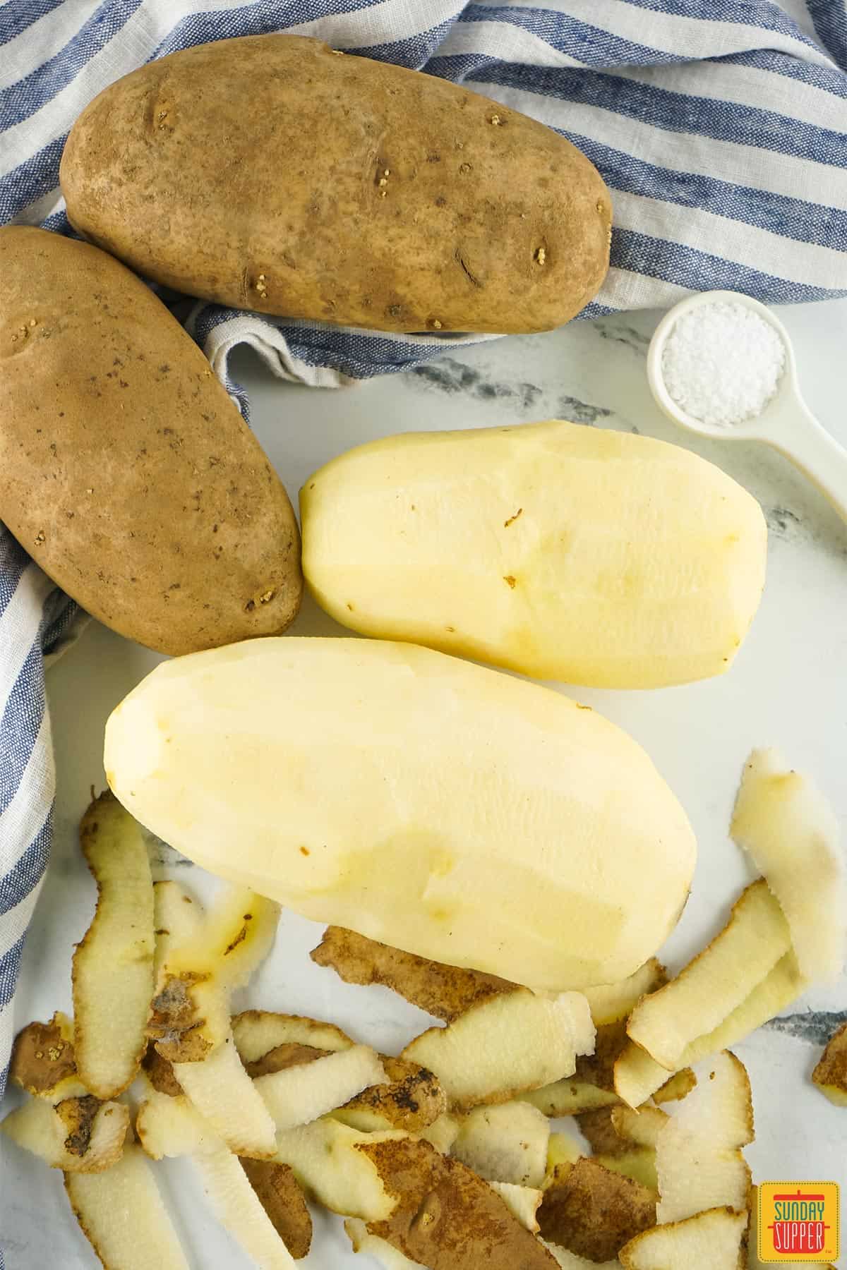 peeled potatoes with a teaspoon of salt