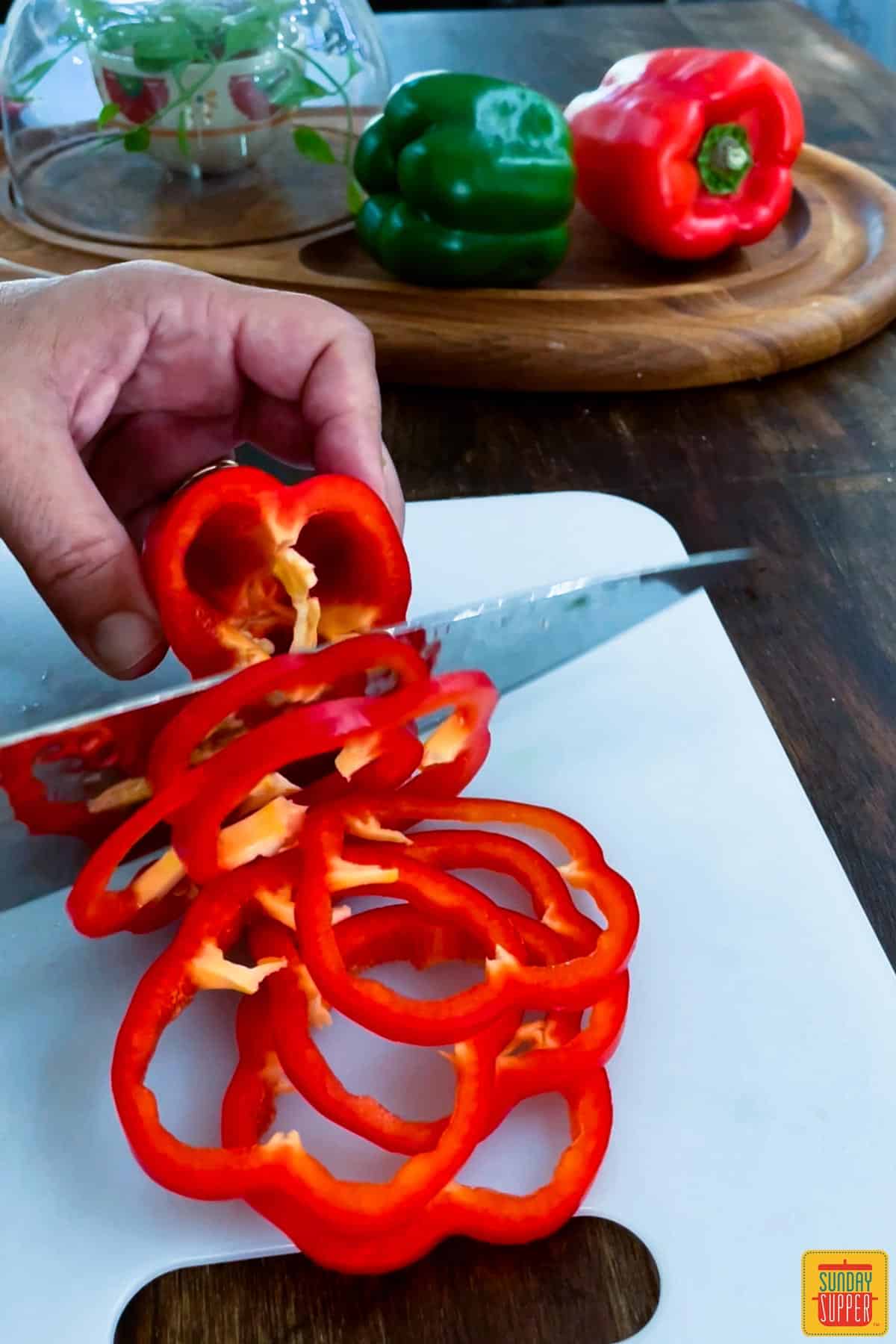 Slicing red bell peppers on a cutting board