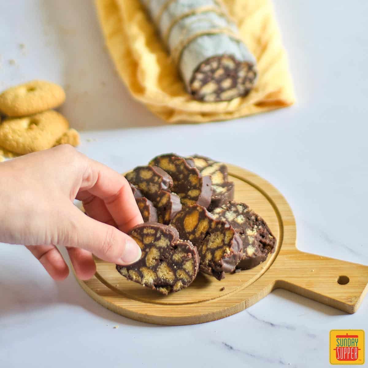Chocolate salami cut into slices on a small wooden board