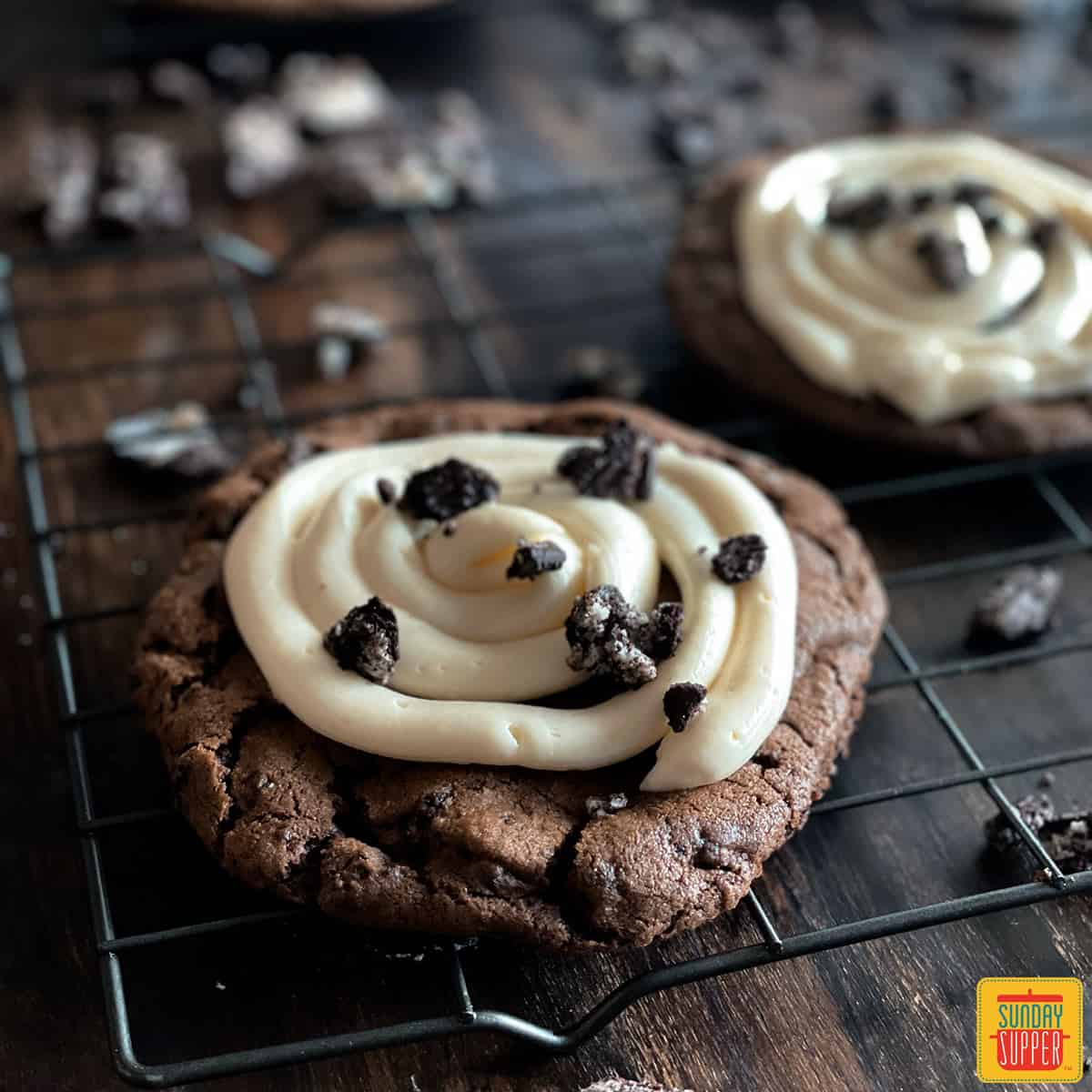 Two crumbl cookies on a baking rack