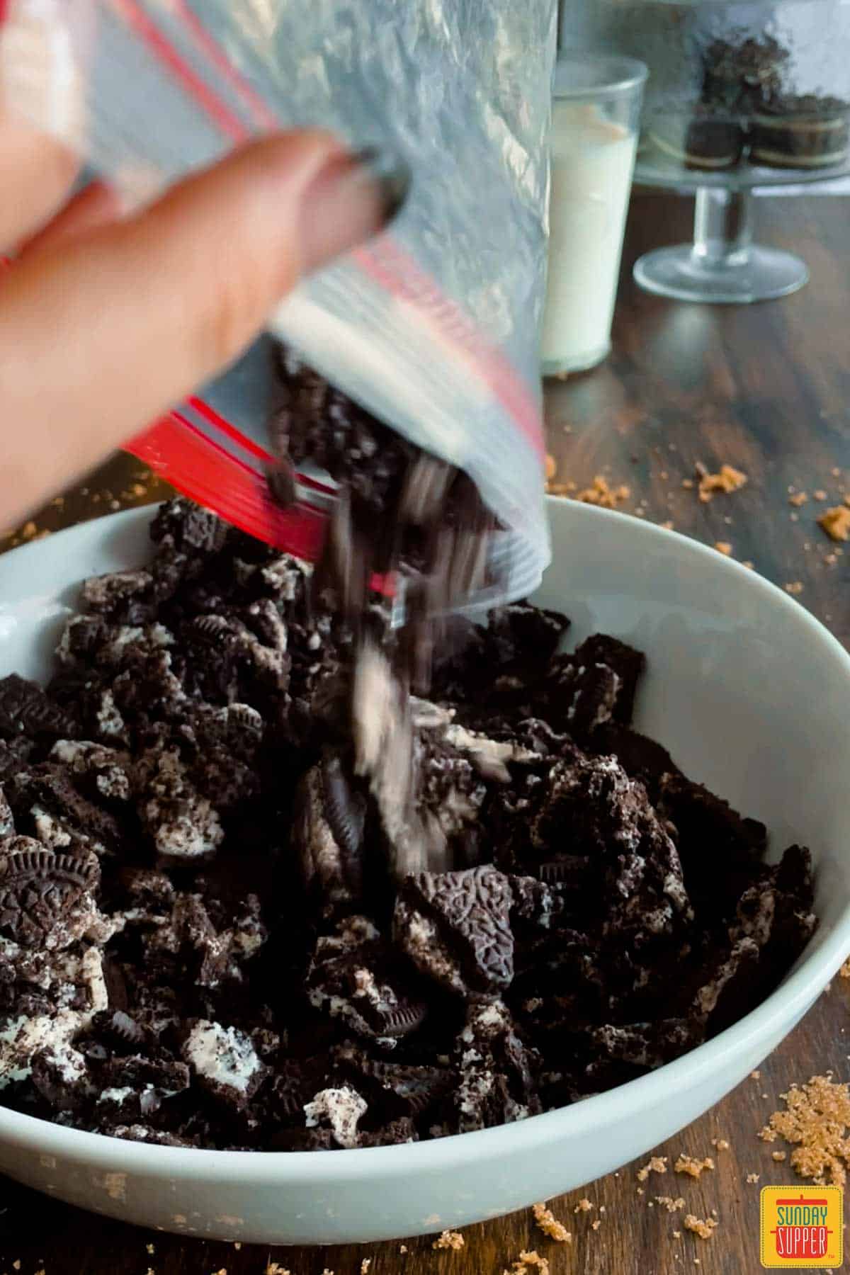 Pouring crushed oreos into a bowl