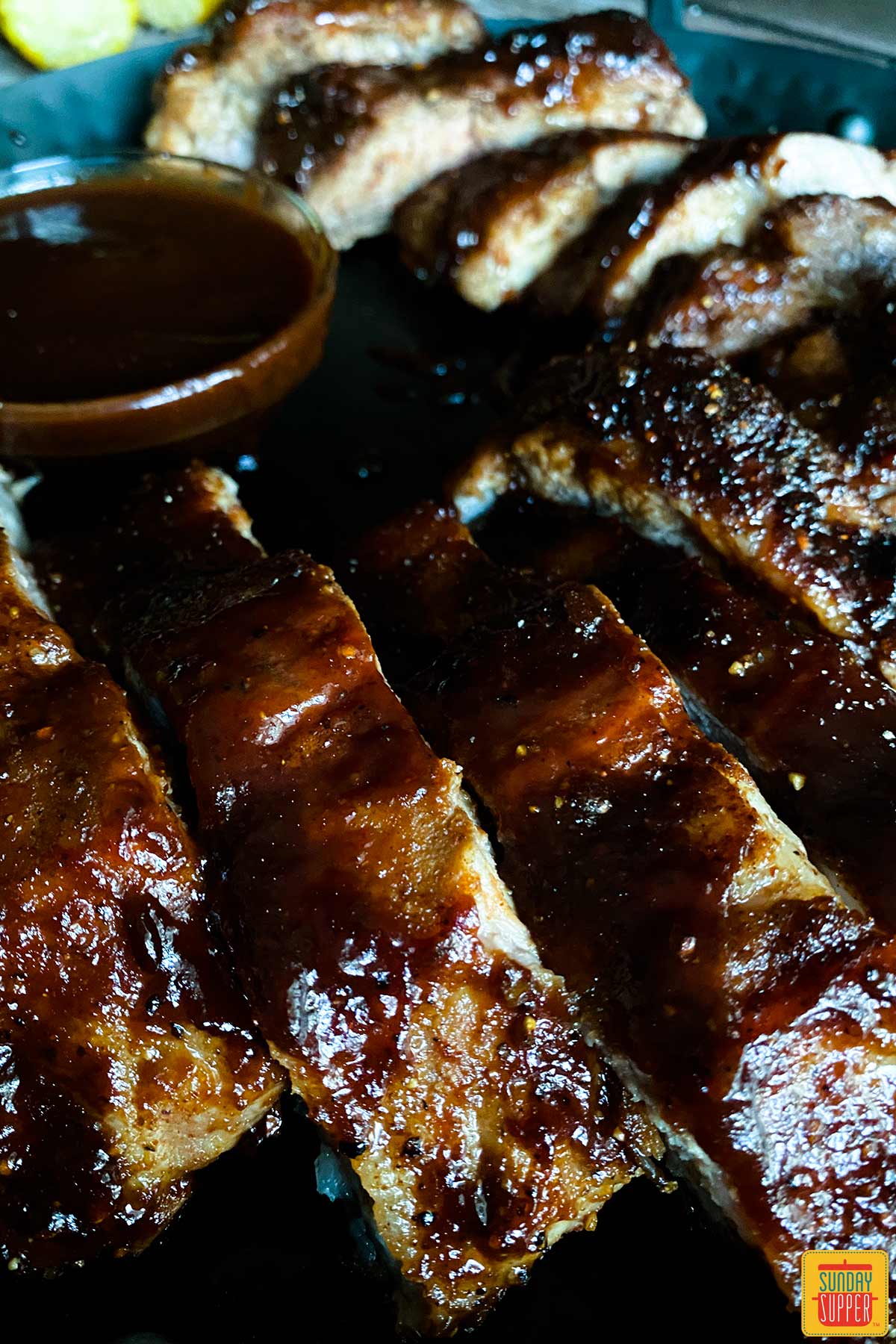 Air fryer baby back ribs on a black plate up close