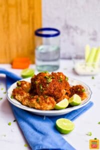 Complete cauliflower wings on a plate with limes