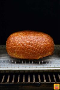 Ham placed in smoker and cooking