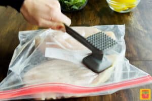 Pounding a chicken breast with a mallet in a bag