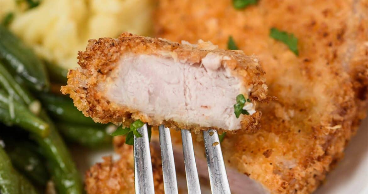 A fork with a bite of air fryer pork chops