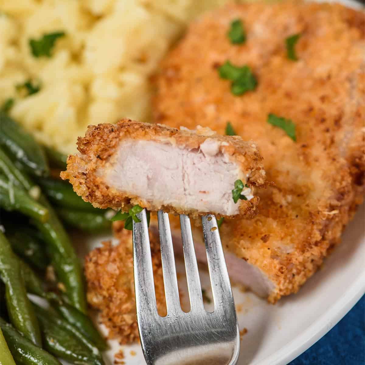 A fork with a bite of air fryer pork chops