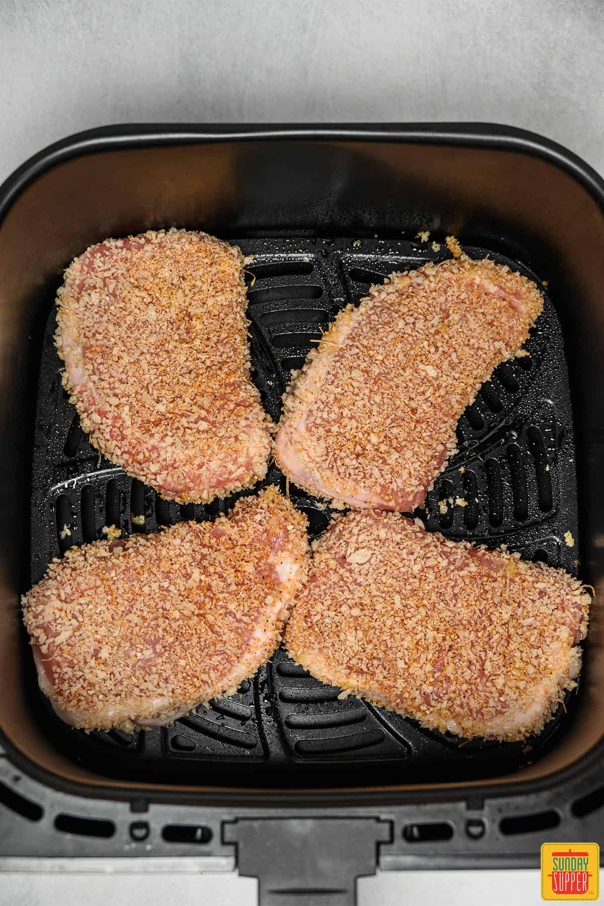 Breaded pork chops in air fryer basket