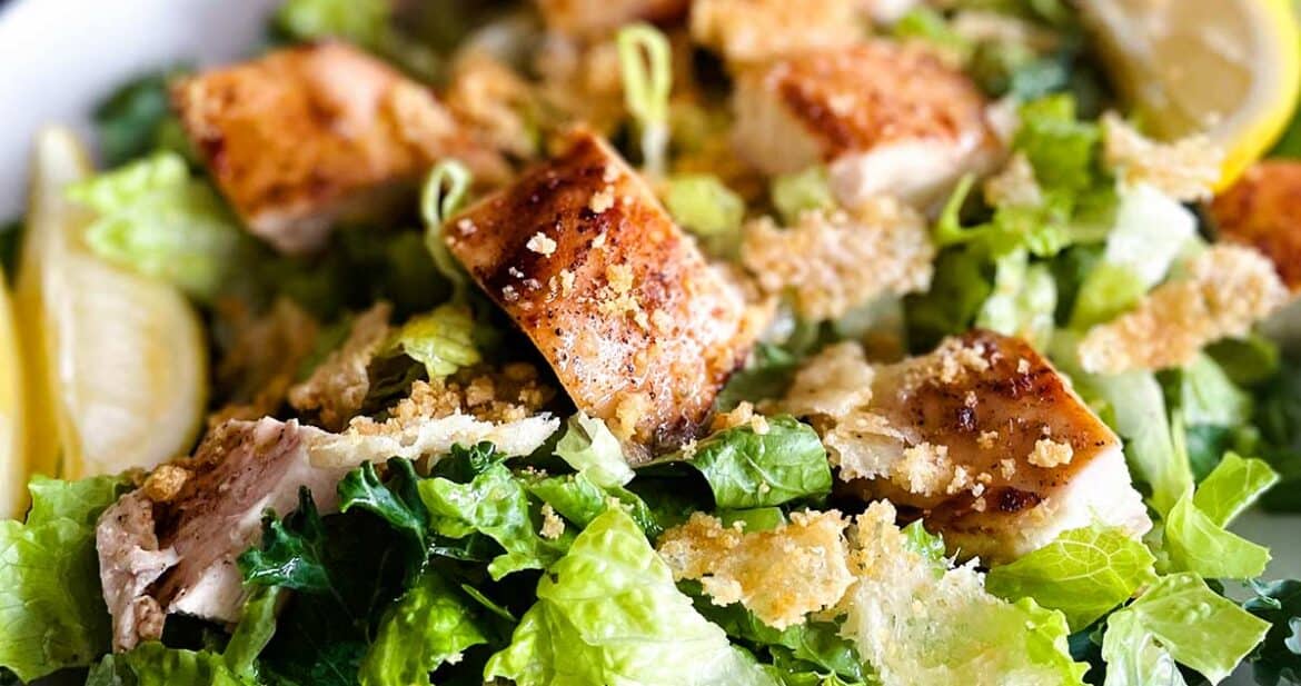 Pouring dressing on chick-fil-a kale caesar salad
