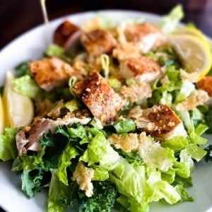 Pouring dressing on chick-fil-a kale caesar salad