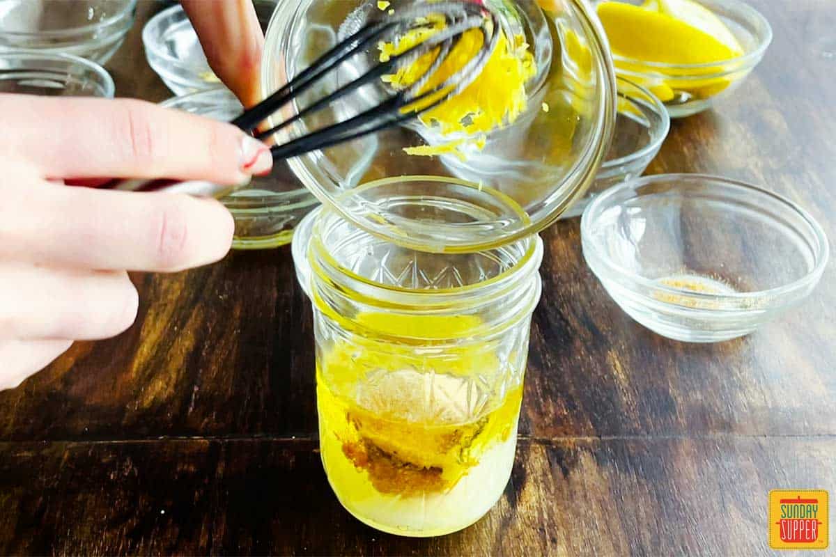 Mixing lemon vinaigrette dressing in a jar 