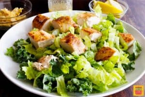 Addign chicken to chick-fil-a lemon kale caesar salad