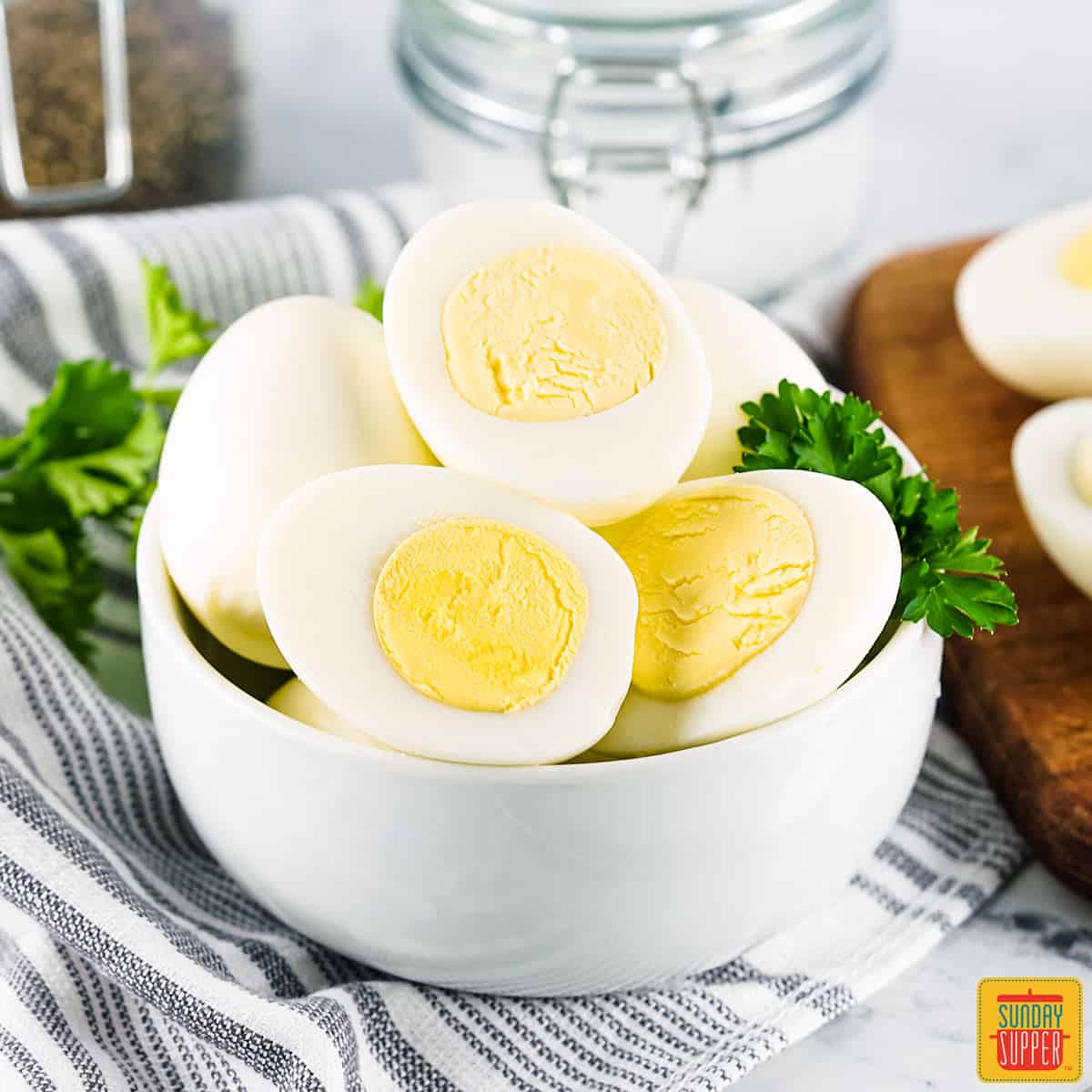 instant pot hard boiled eggs sliced in half in a white bowl