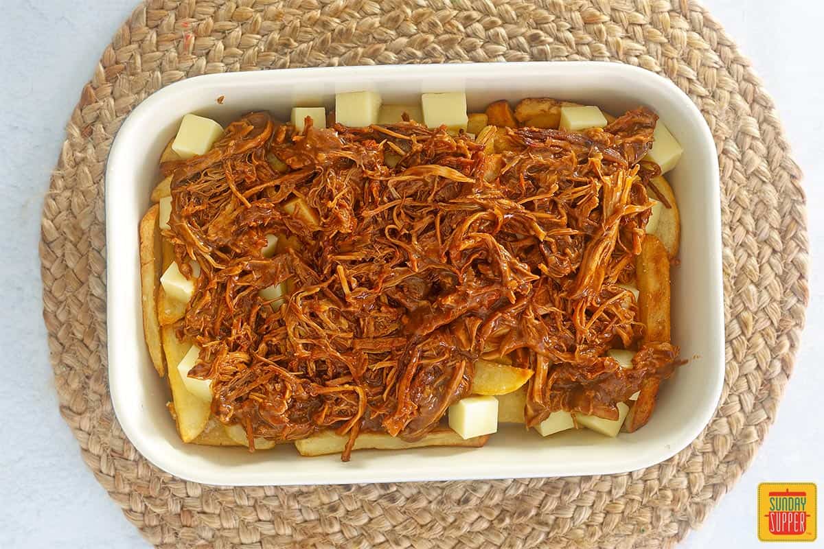 pulled pork poutine in a baking dish