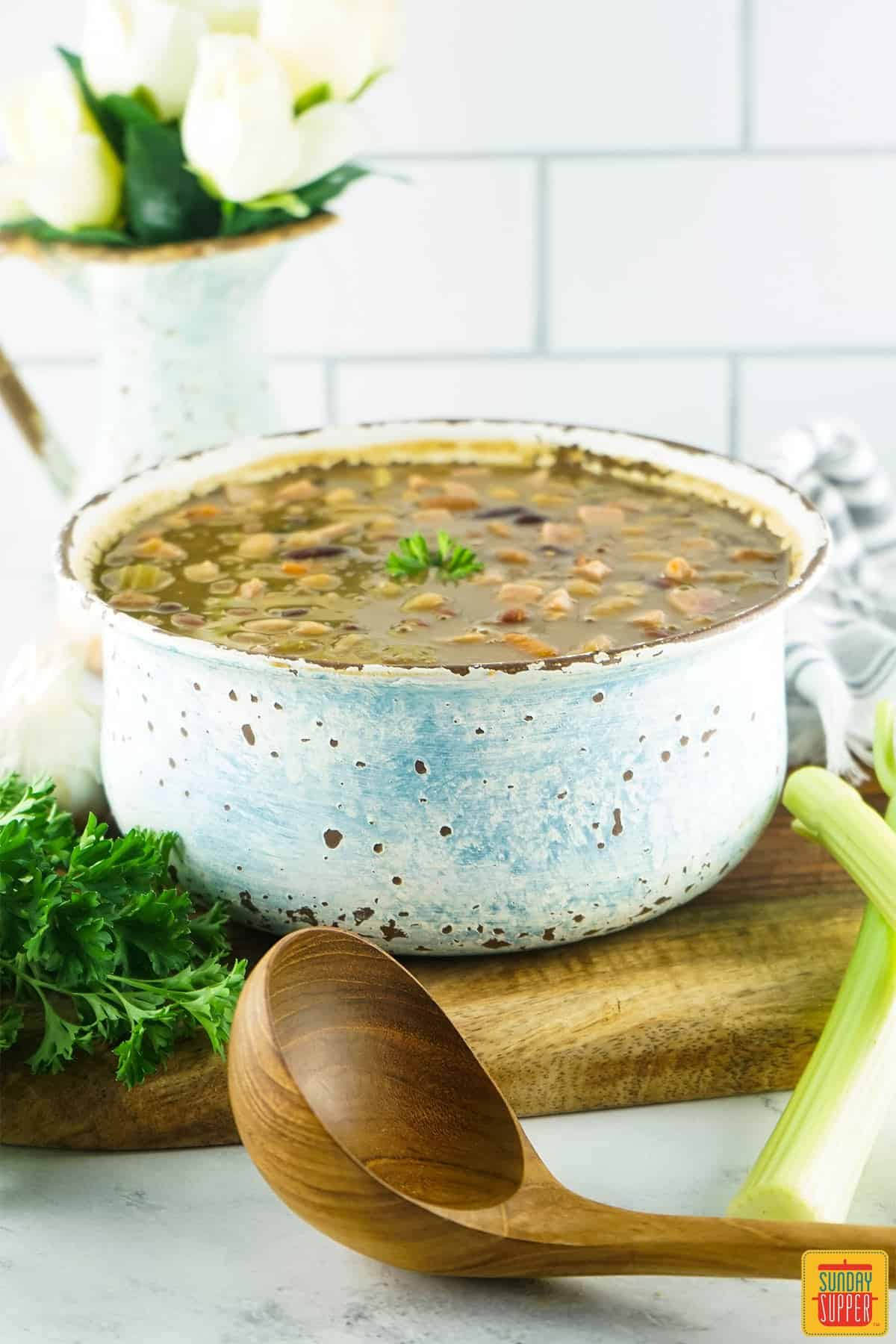 instant pot 15-bean soup in a bowl with a large wooden ladle