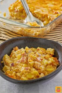 cheesy ham and potatoes casserole in a dish next to the baking dish