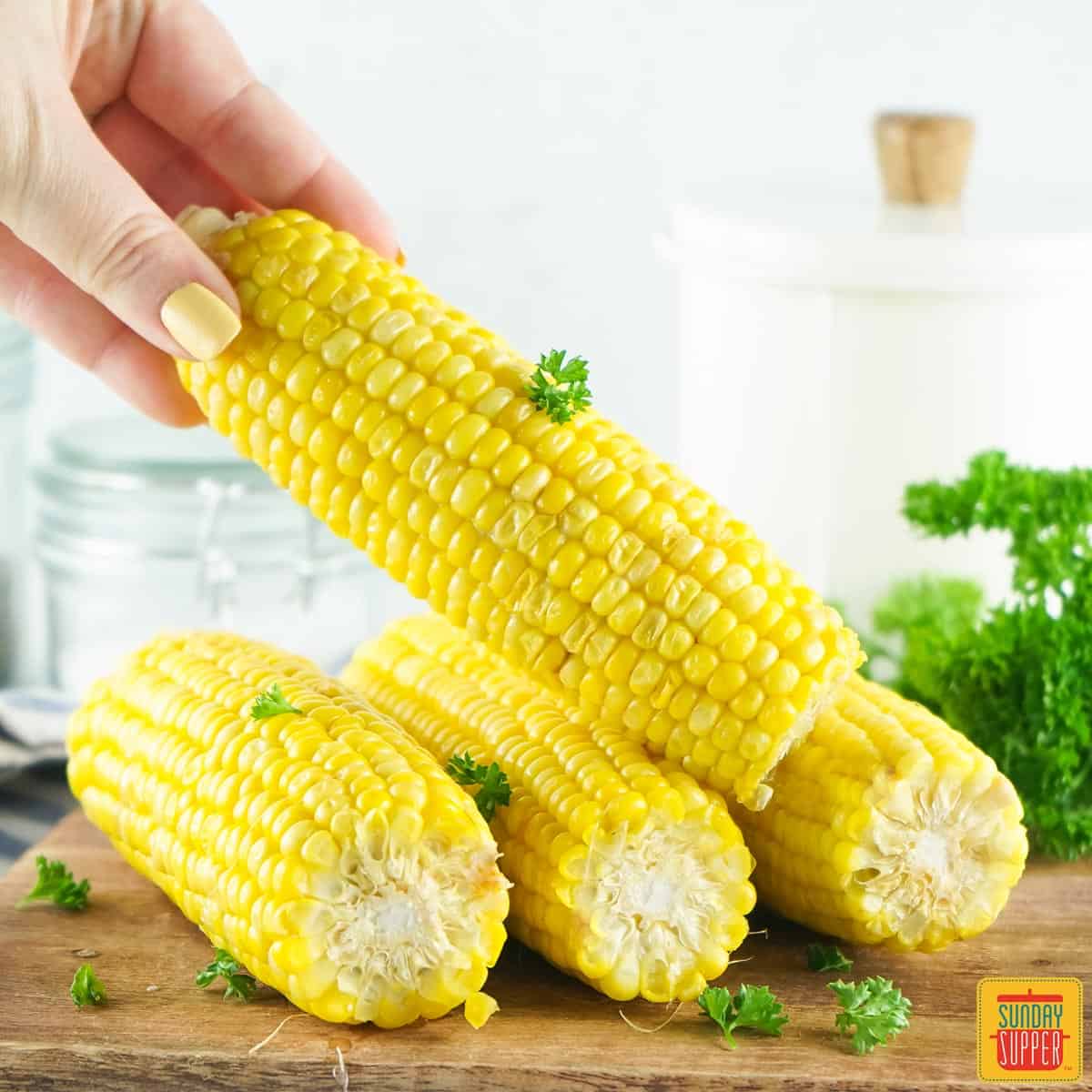 Picking up a cooked corn on the cob