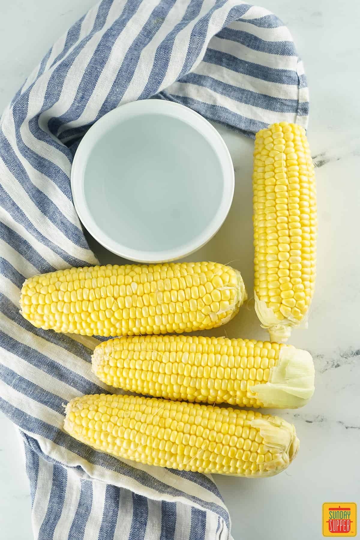 uncooked corn with a cup of water
