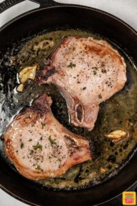 pan seared pork chops in skillet with butter