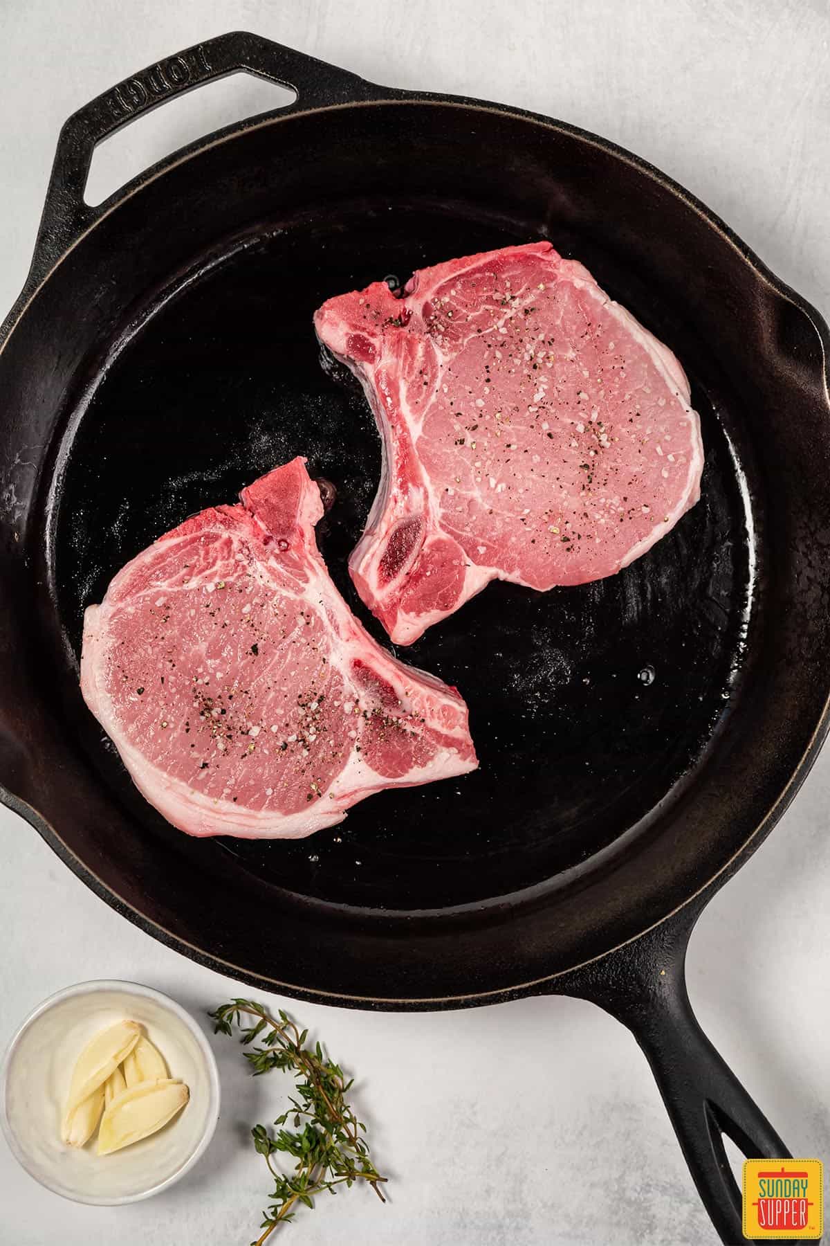 pork chops searing in pan