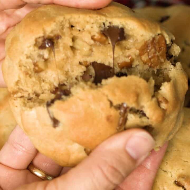 breaking levain cookie in half to show chocolate chips