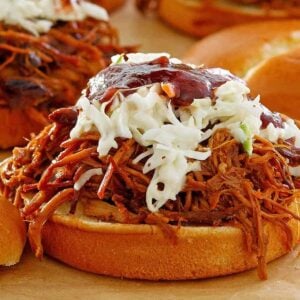 Pulled pork piled on a sandwich with coleslaw