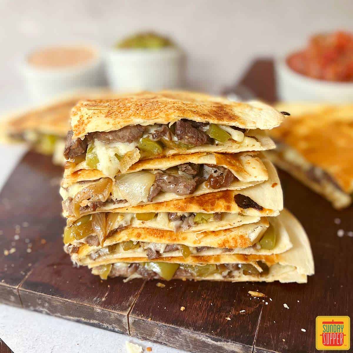 steak quesadillas cut into fourths on a cutting board