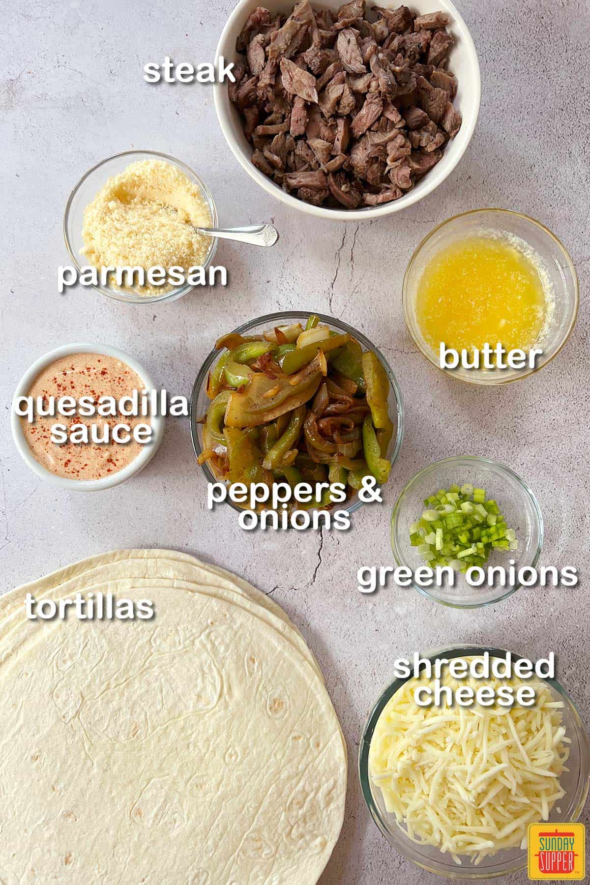 ingredients for steak quesadillas on a white surface