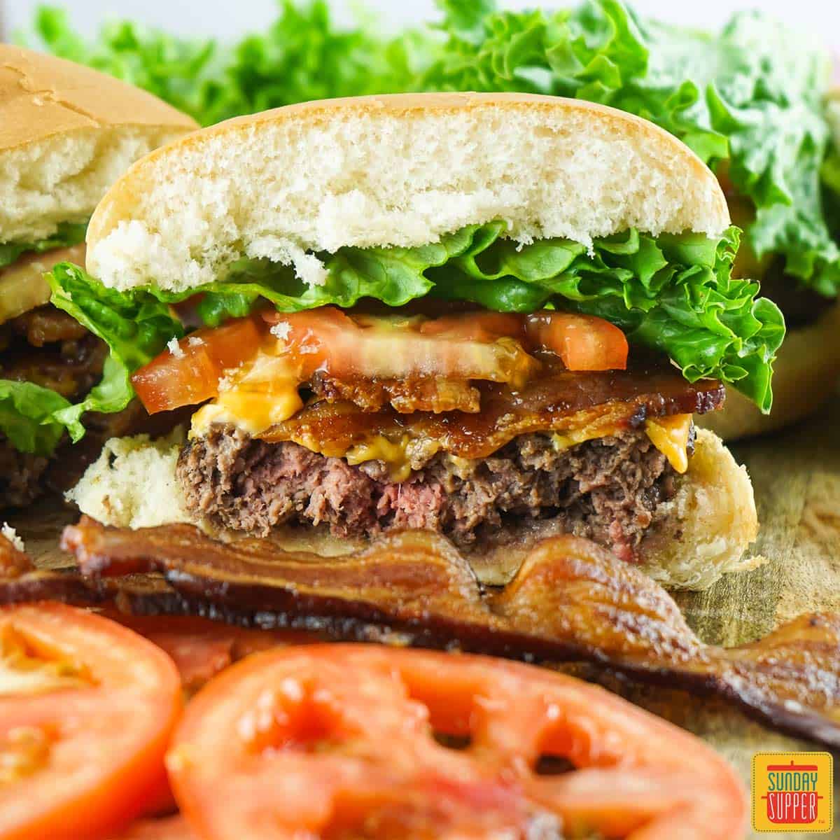 wagyu burger sliced in half with tomato slices