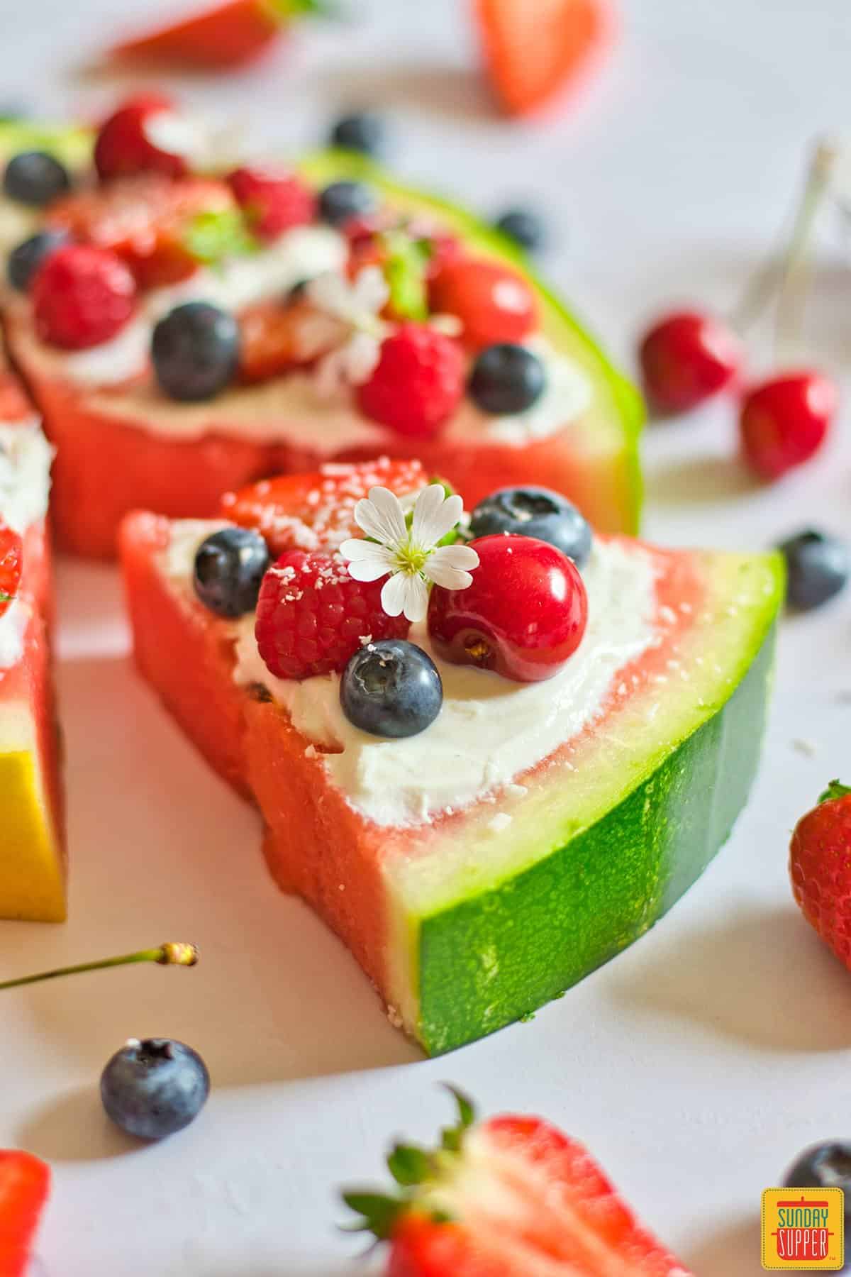 watermelon pizza slice with fresh fruit and a tiny flower