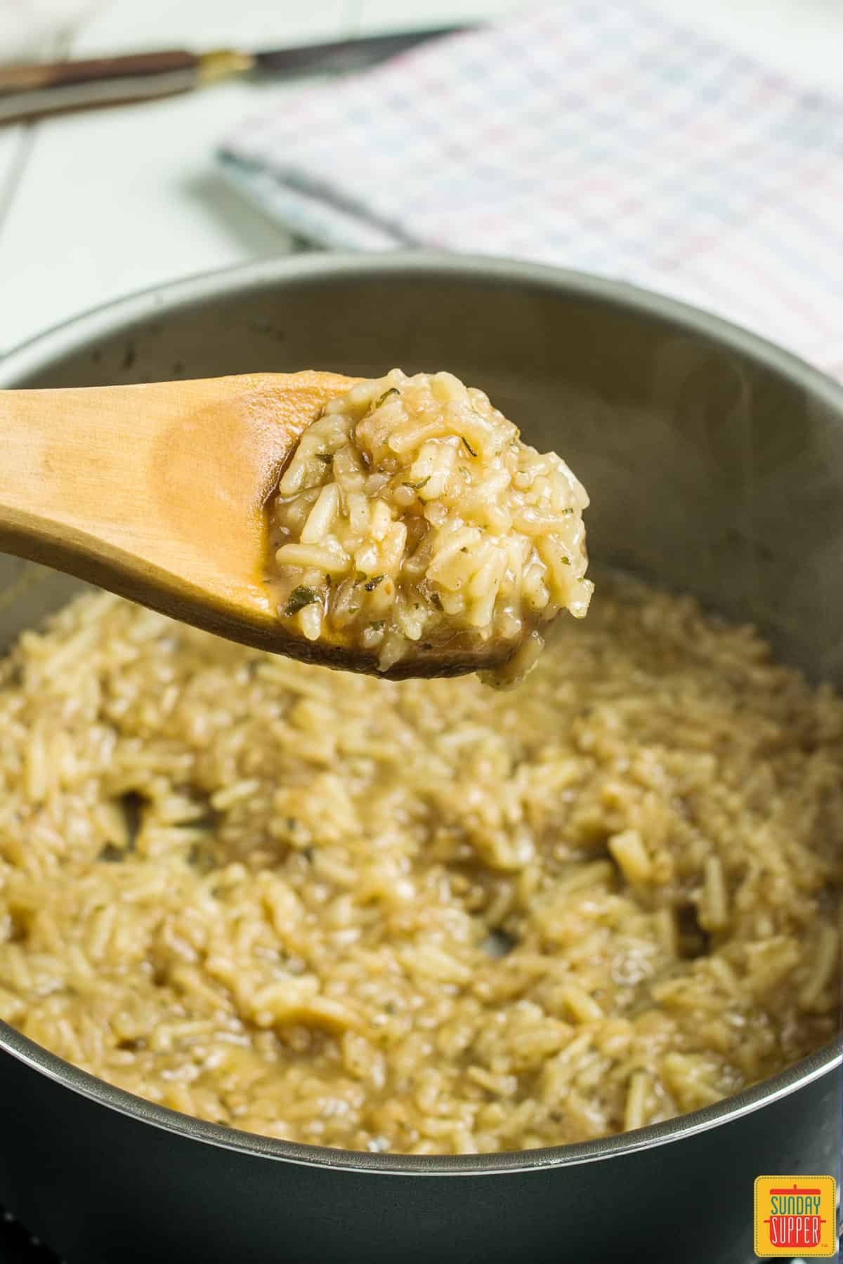 rice-a-roni on a wooden spoon over a pot of rice-a-roni