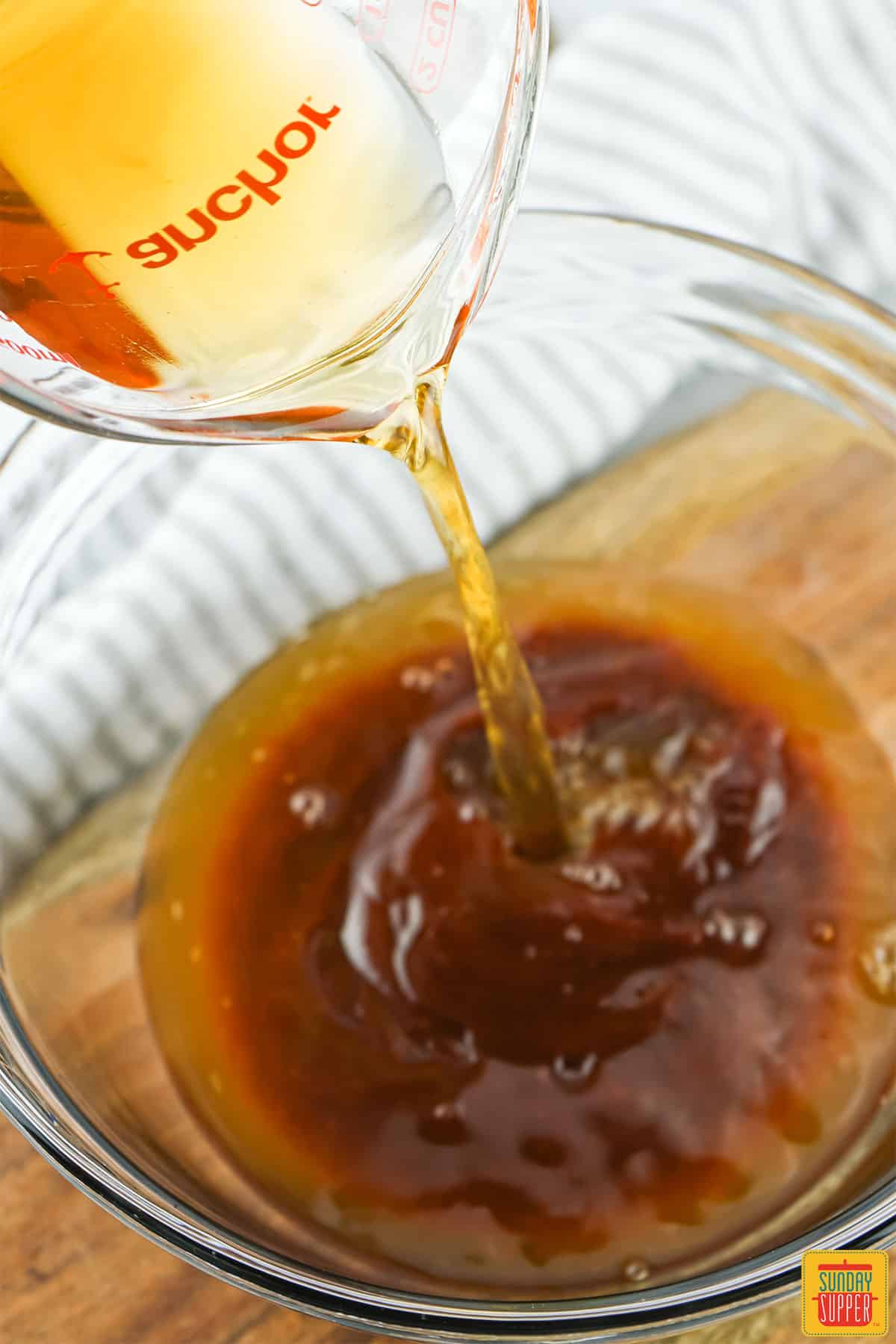 Pouring vinegar in a bowl with bbq sauce